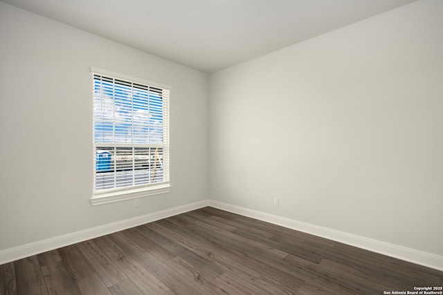 unfurnished room with dark hardwood / wood-style flooring