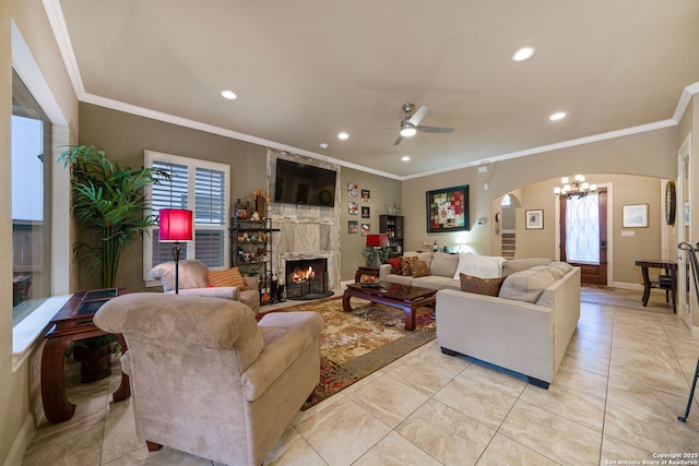 living room featuring ornamental molding, a stone fireplace, light tile patterned floors, and ceiling fan