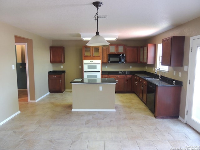 kitchen with sink, hanging light fixtures, black appliances, and a center island