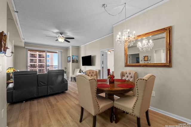 dining space with crown molding, a textured ceiling, ceiling fan, and light wood-type flooring