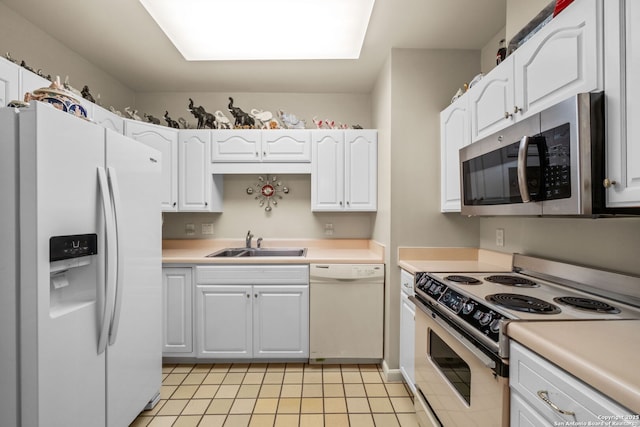 kitchen with stainless steel appliances, white cabinetry, sink, and light tile patterned floors