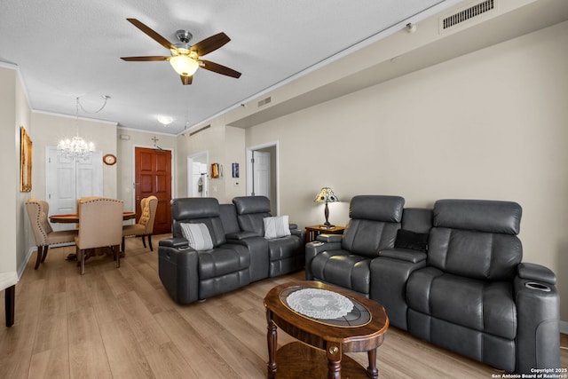 living room featuring ceiling fan with notable chandelier, ornamental molding, light hardwood / wood-style floors, and a textured ceiling