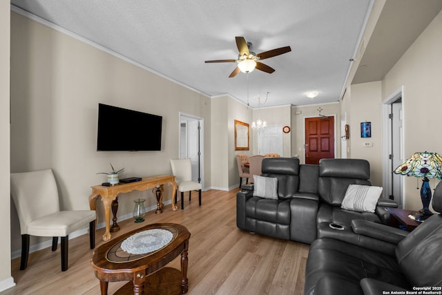 living room featuring crown molding, ceiling fan with notable chandelier, light hardwood / wood-style flooring, and a textured ceiling