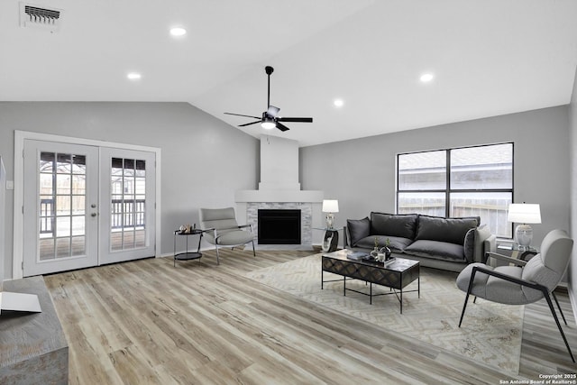 living room with vaulted ceiling, ceiling fan, light hardwood / wood-style floors, and french doors