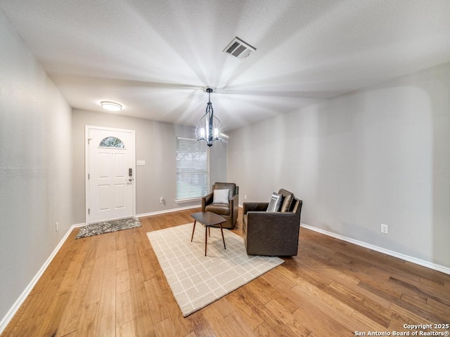 living area featuring hardwood / wood-style floors and an inviting chandelier