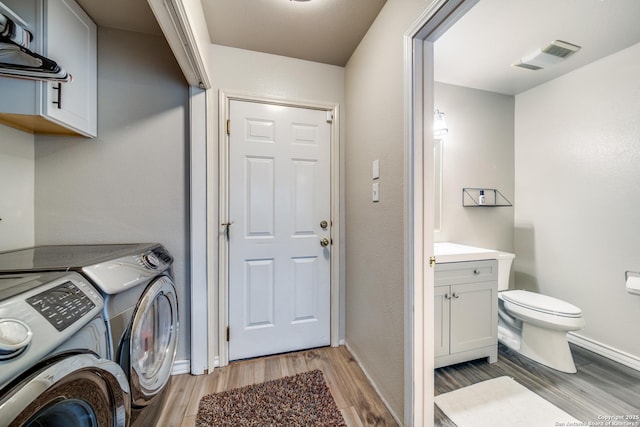 laundry area featuring light hardwood / wood-style flooring and washer and clothes dryer