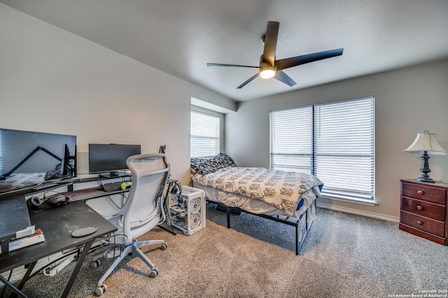 carpeted bedroom with ceiling fan and a textured ceiling