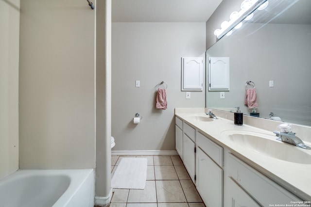 bathroom with tile patterned flooring, vanity, a bathtub, and toilet