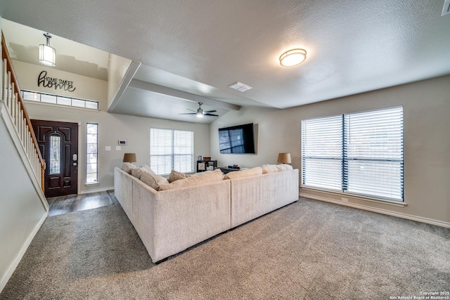 carpeted living room with ceiling fan, vaulted ceiling, and a textured ceiling