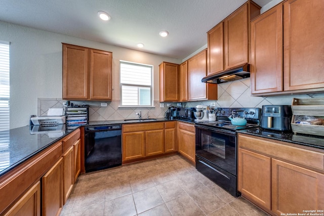 kitchen featuring sink, backsplash, dark stone counters, and black appliances