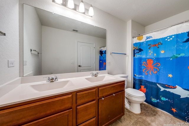 bathroom featuring vanity, tile patterned flooring, and toilet