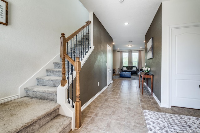 stairway with tile patterned floors