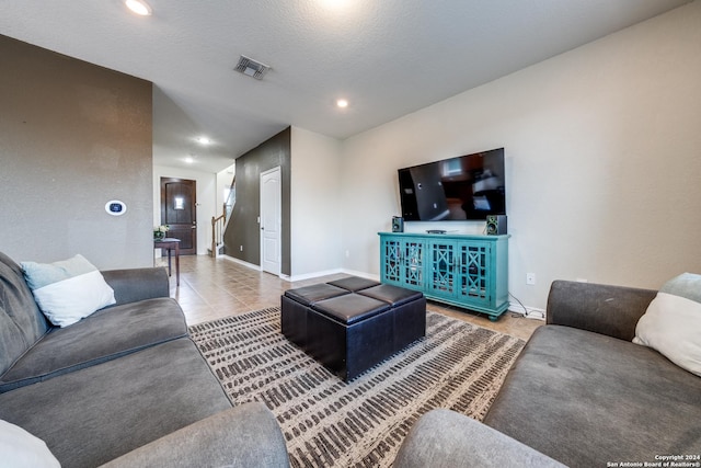 living room featuring a textured ceiling and light tile patterned floors