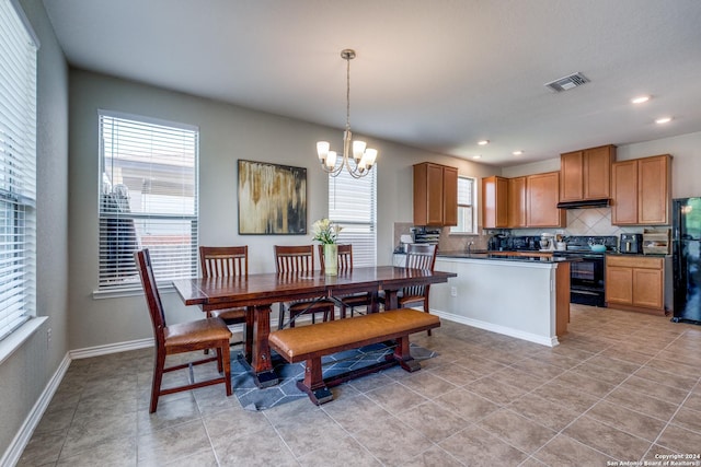 dining room featuring light tile patterned flooring and a notable chandelier