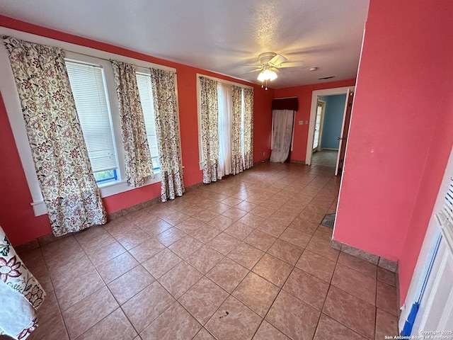 empty room featuring ceiling fan and light tile patterned floors