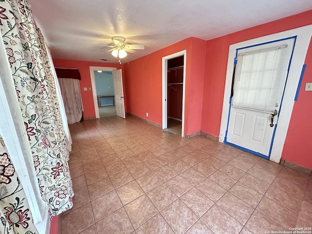 entrance foyer featuring light tile patterned floors, a textured ceiling, and ceiling fan