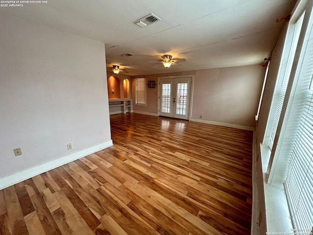 unfurnished living room featuring light hardwood / wood-style flooring, ceiling fan, and french doors