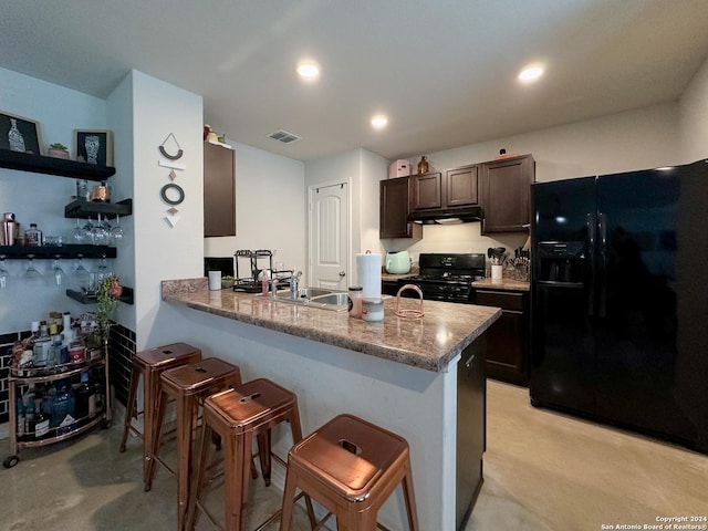 kitchen with a breakfast bar, black appliances, sink, kitchen peninsula, and dark brown cabinets