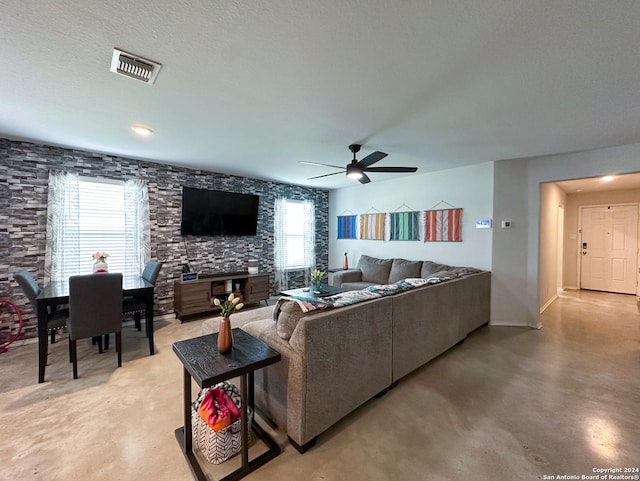 living room featuring a textured ceiling and ceiling fan