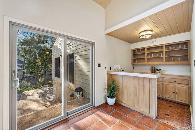 interior space featuring tile patterned floors, light brown cabinetry, and wooden ceiling