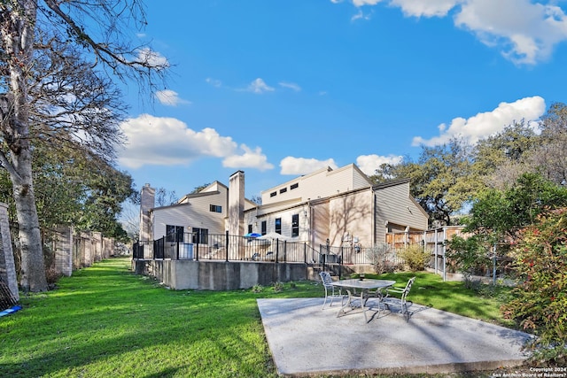 rear view of house with a patio and a yard