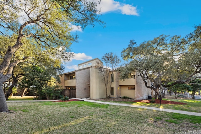 view of front of property with cooling unit and a front yard