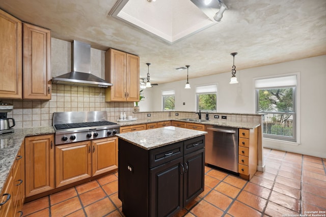 kitchen with a kitchen island, sink, kitchen peninsula, stainless steel appliances, and wall chimney exhaust hood