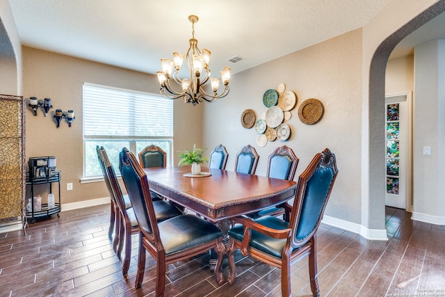 dining area featuring a notable chandelier and a textured ceiling