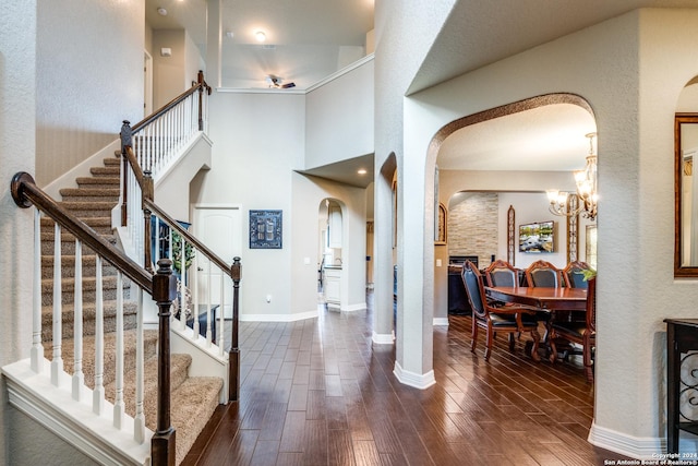 entryway with a high ceiling, dark hardwood / wood-style floors, and an inviting chandelier