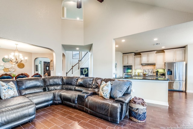 living room featuring high vaulted ceiling and a notable chandelier