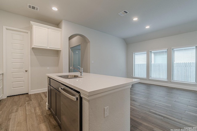 kitchen featuring sink, dishwasher, an island with sink, light hardwood / wood-style floors, and white cabinets