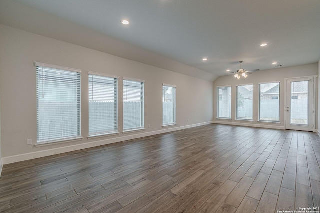 empty room featuring hardwood / wood-style flooring, vaulted ceiling, and ceiling fan