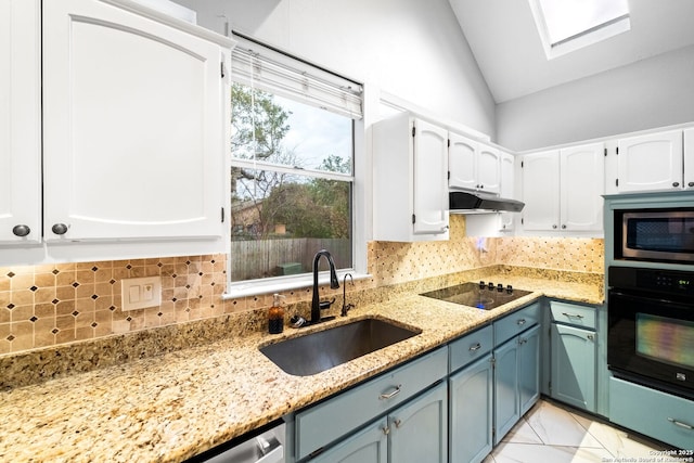 kitchen with white cabinetry, sink, light stone counters, and black appliances