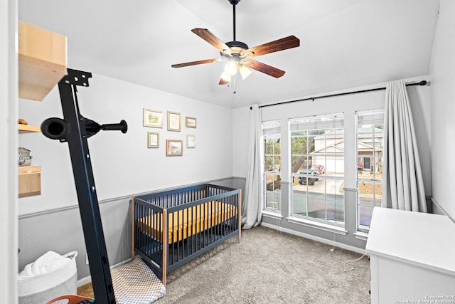 bedroom with a crib, carpet flooring, and ceiling fan