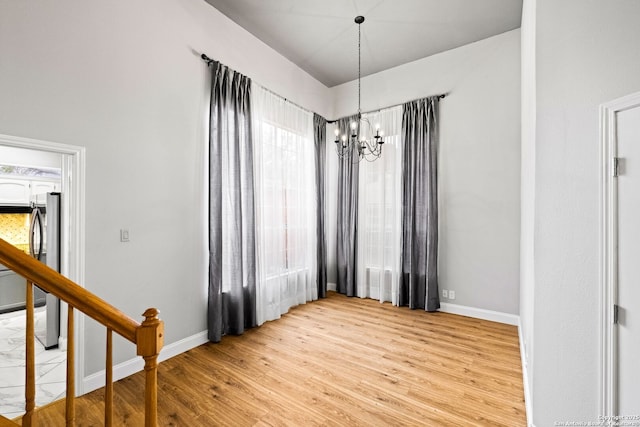 unfurnished dining area with light hardwood / wood-style flooring and a chandelier