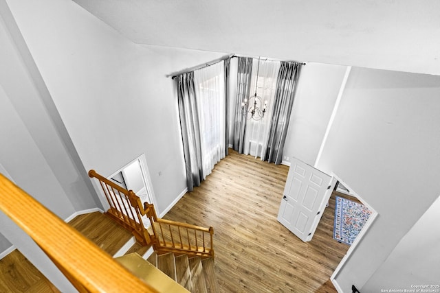 stairs with an inviting chandelier and wood-type flooring