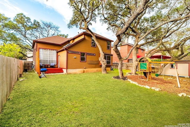 rear view of property featuring a yard and a playground