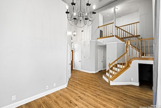 interior space featuring hardwood / wood-style flooring, a high ceiling, and a notable chandelier