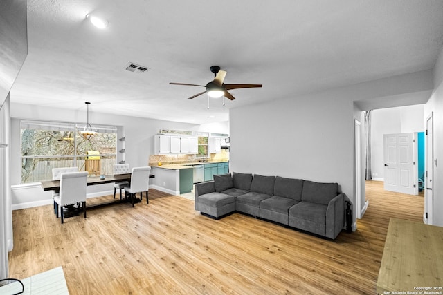 living room with sink, light hardwood / wood-style flooring, and ceiling fan