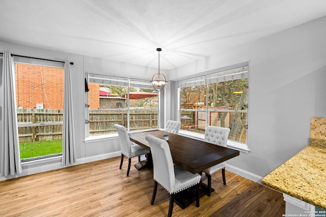 dining room with hardwood / wood-style flooring and a chandelier