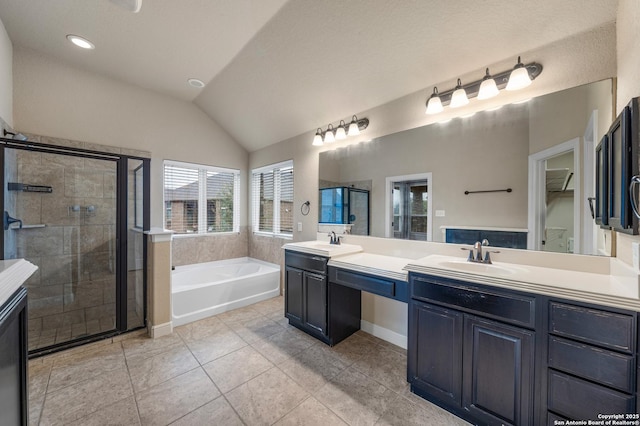 bathroom with tile patterned flooring, vanity, separate shower and tub, and vaulted ceiling