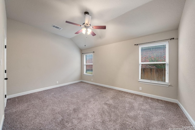 spare room featuring vaulted ceiling, carpet floors, and ceiling fan