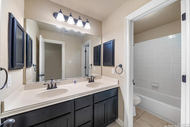 full bathroom with tiled shower / bath combo, vanity, a textured ceiling, tile patterned floors, and toilet