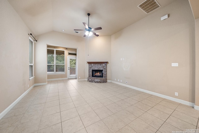 unfurnished living room featuring ceiling fan, vaulted ceiling, light tile patterned flooring, and a fireplace