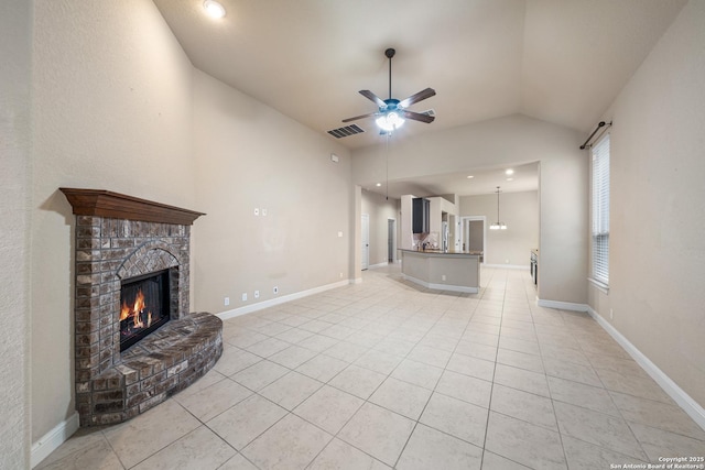 unfurnished living room featuring light tile patterned flooring, vaulted ceiling, ceiling fan, and a fireplace