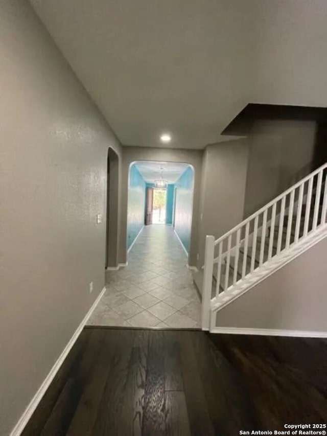 hall featuring light hardwood / wood-style floors and a notable chandelier