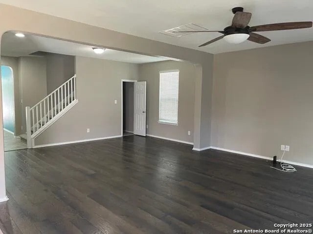 empty room with ceiling fan and dark wood-type flooring