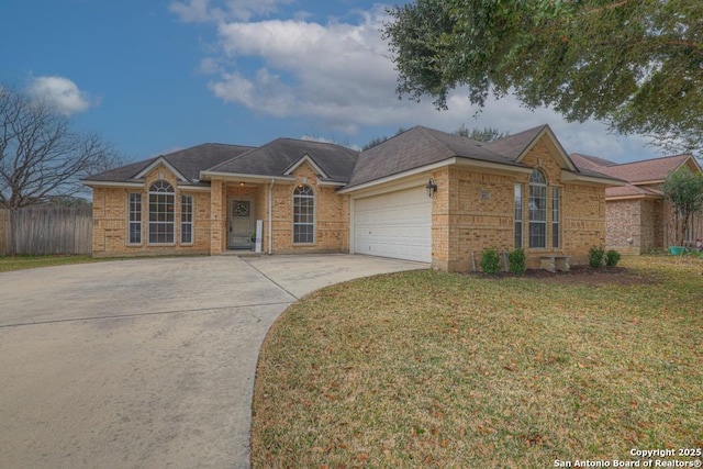 ranch-style house featuring an attached garage, brick siding, fence, concrete driveway, and a front yard