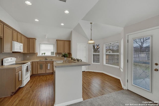 kitchen featuring recessed lighting, white appliances, vaulted ceiling, light wood-type flooring, and pendant lighting