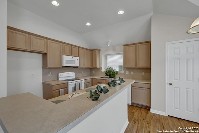 kitchen featuring lofted ceiling, light wood-style flooring, recessed lighting, white appliances, and light countertops